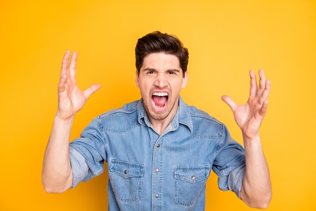 Photo of grimacing rude screaming man annoyed with bad work of\
his colleagues isolated over vivid color wall