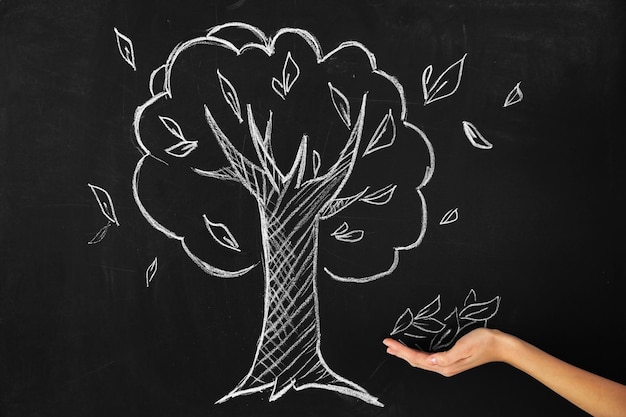 Photo of hand catching leaves painted on chalkboard