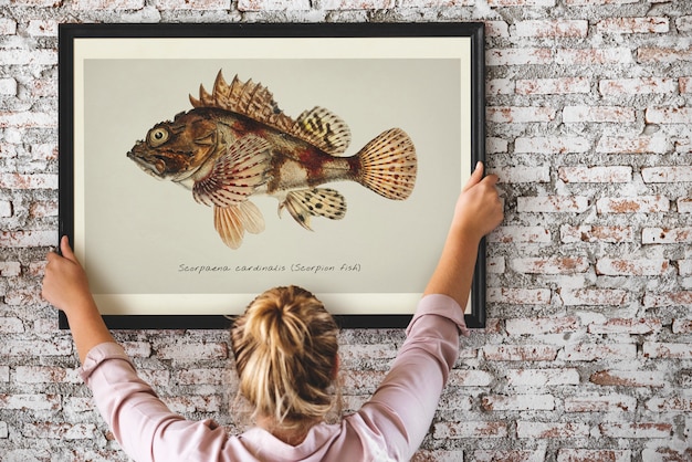 La foto della mano che disegna il pesce nel telaio