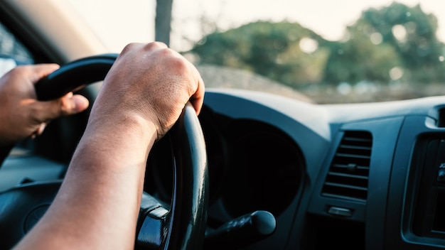 Photo photo of the hand is controlling the steering wheel.