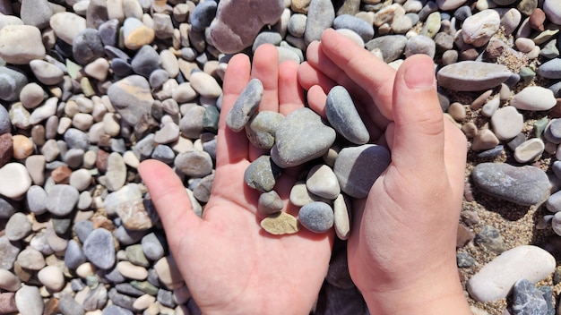 photo of a handful of sea pebbles in the hands