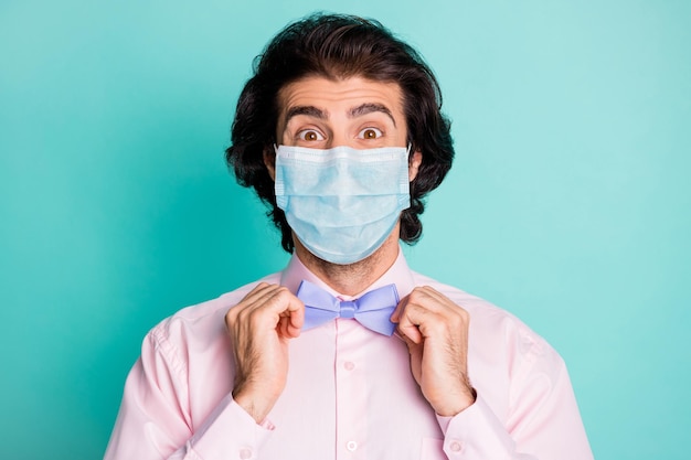 Photo of handsome cute boyfriend wear pink medical mask two arms fix bow tie isolated teal color background