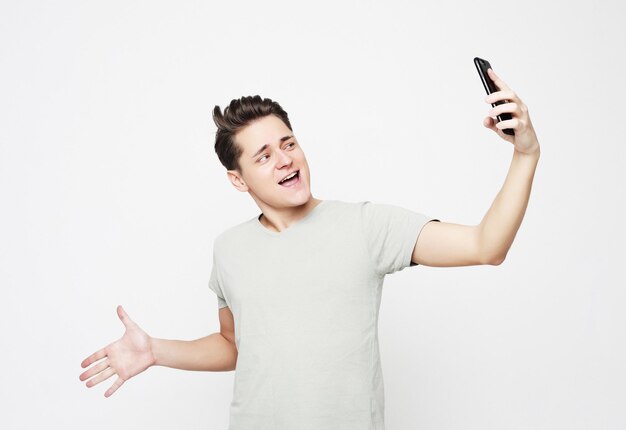 Photo of handsome man smiling on camera taking selfie