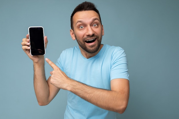 Foto di una persona maschio adulta sorridente felice e felice di bell'aspetto che indossa abiti casual in piedi