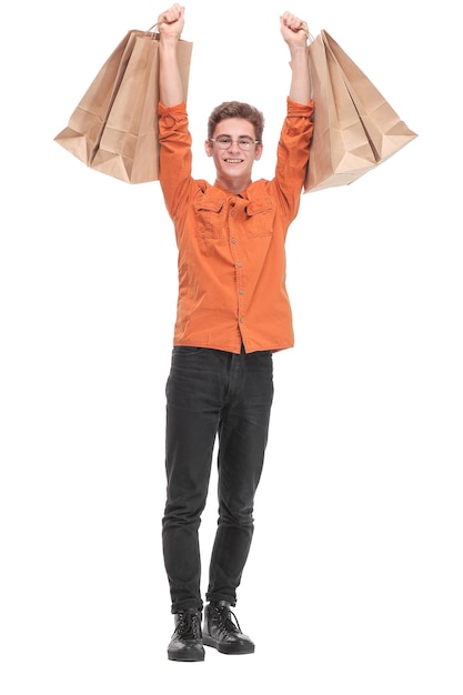 Фото красивого молодого успешного мужчины, поднимающего сумки с покупками, взволнованного настроения, покупки одежды