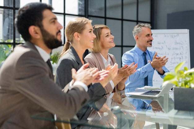 Photo of happy business people applauding at conference