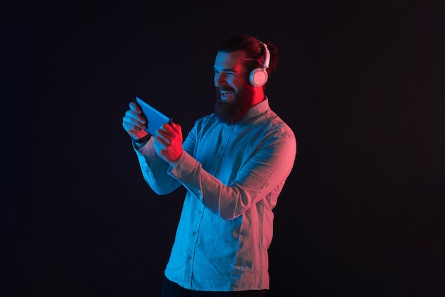 Photo of happy cheerful bearded hipster man playing games