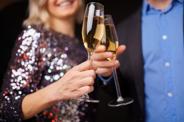 Photo of happy couple with champagne glasses in studio