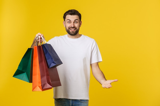 Photo of happy guy, holding shopping bags, isolated