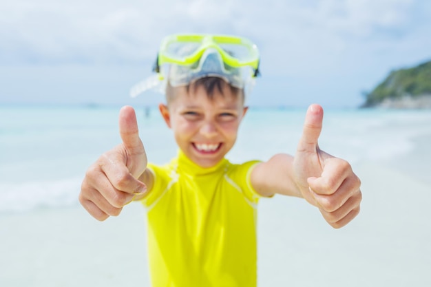 Foto di un ragazzo felice che fa snorkeling in costume da bagno giallo