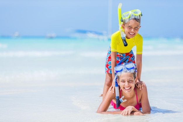 Photo of happy snorkeling girl and boy on the white beach