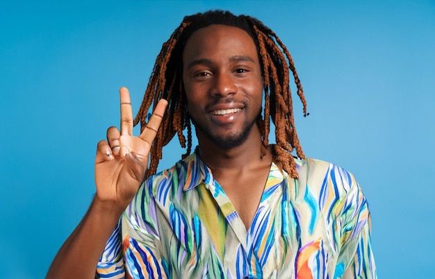 photo happy young african man dreadlocks with peace gesture wearing beach shirt on blue background