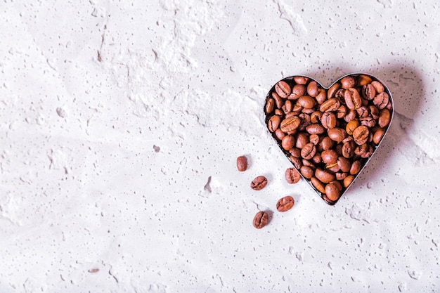 Photo of Heart-shaped coffee beans copy space on concrete background. Horizontal photo. Top view