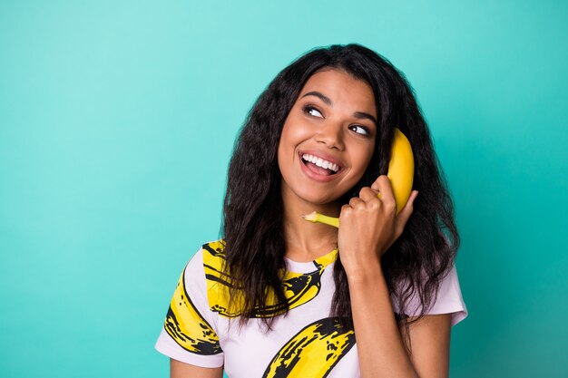 Photo of inspired dark skin girl call banana cellphone isolated over turquoise color background