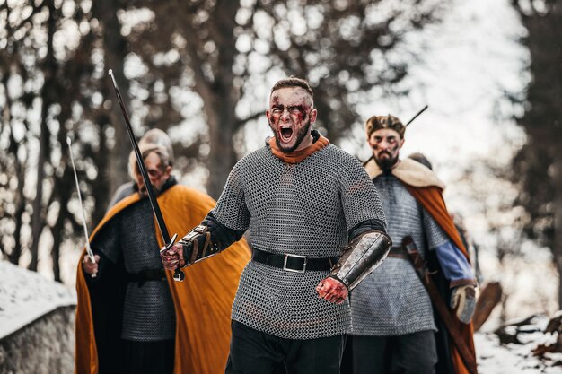 Foto dei cavalieri in armatura con le spade durante la guerra. emozioni malvagie di un guerriero che va a combattere con la spada