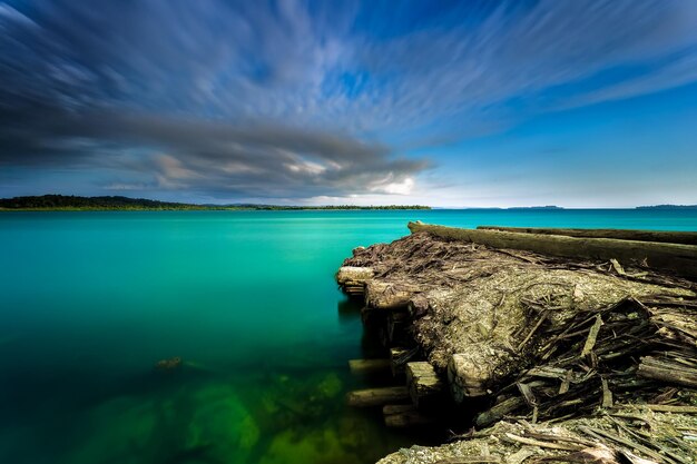 Фото озера со скалами и голубого неба с облаками