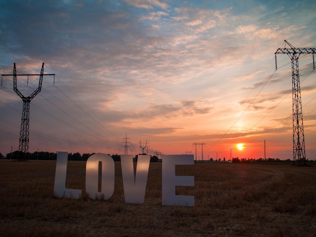 Photo love big plastic letters on a background of sky and sunset