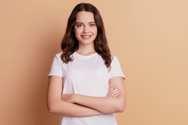 Photo of lovely charming positive lady folded hands posing on beige background