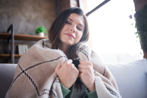 Foto la foto di una ragazza adorabile si diverte a coprire la coperta a scacchi in una casa moderna