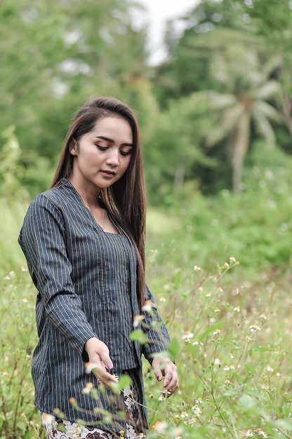 a photo of a lurik kebaya model in the open.