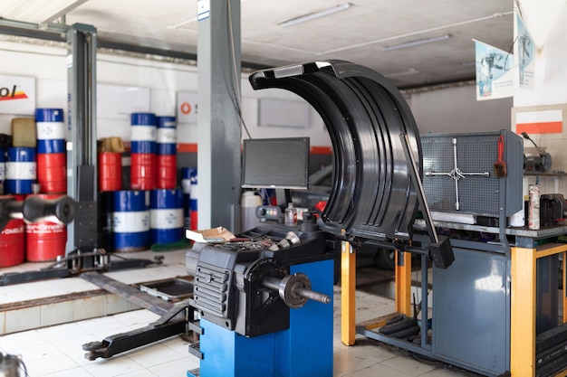 Photo of a machine for balancing wheels and repairing tires of an auto against the background of a service station