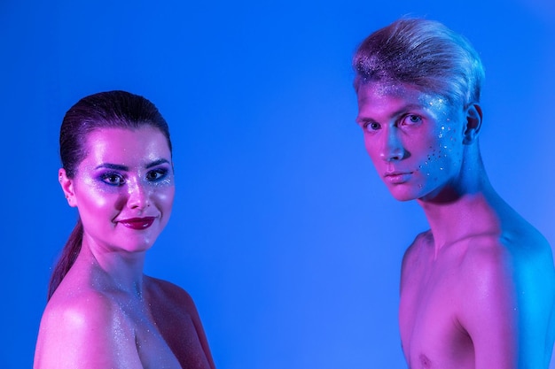 Photo of Male and female models in the studio with color filters Closeup of models in neon purple and blue light