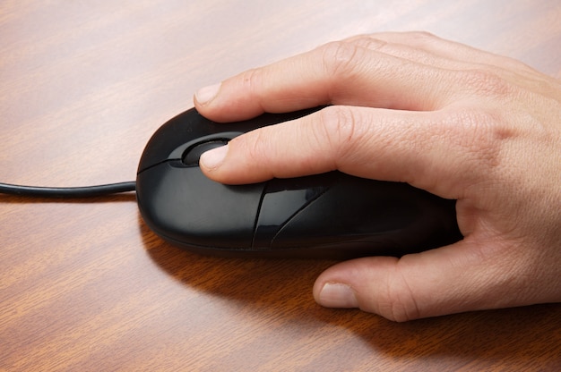 A photo of a male hand and a mouse