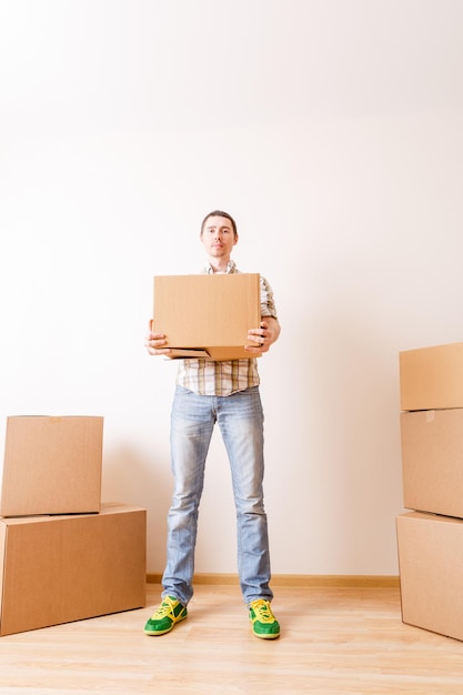 Photo photo of man standing among cardboard boxes