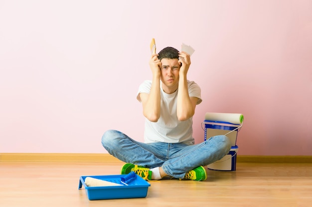 Photo of man with brush sitting on floor