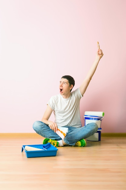 Photo of man with brush sitting on floor