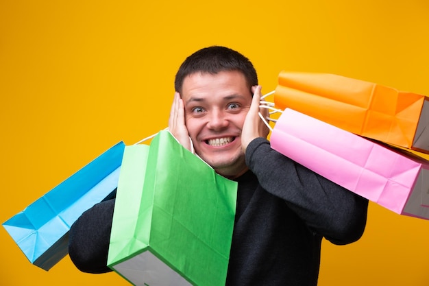 Photo of man with multicolored shopping bags