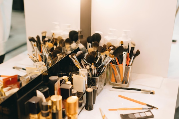 Photo of many accessories for makeup near table and mirror