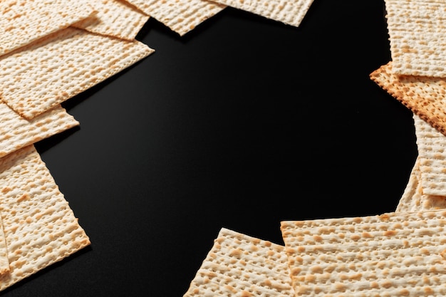 A photo of matzah or matzo pieces  on black. Matzah for the Jewish Passover holidays. 