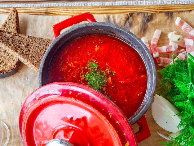 Photo for menu Russian borscht in red pot with sour cream garlic bread parsley dill lard Ukrainian b