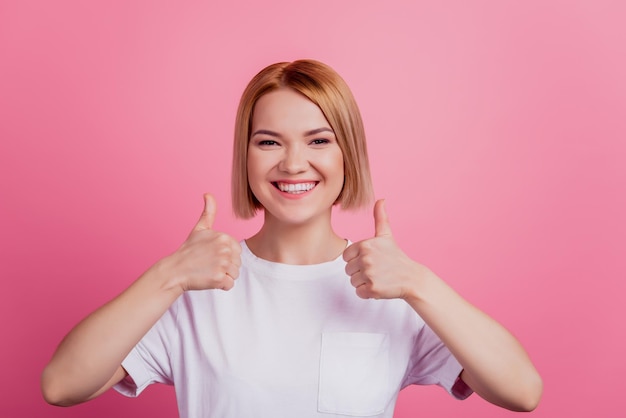 Photo of nice charming blonde lady raise thumb up agree concept wear white t-shirt isolated on pink background