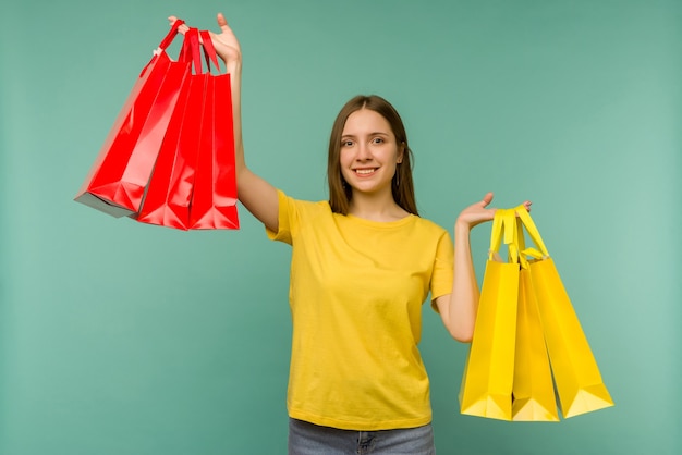 Photo of nice charming girl attractive joyful girl having just ended up shopping and being overjoyed and cheerful while with blue