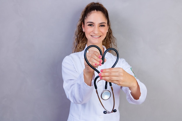 Фотография медсестры, держащей стетоскоп на сером