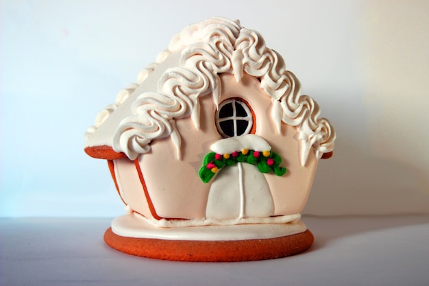 사진 흰색 바탕에 생강 산타 쿠키 하우스의 사진. 크리스마스 장식