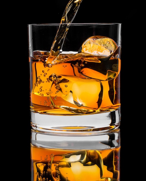 写真 黒の背景にウイスキーと氷のガラスの写真
