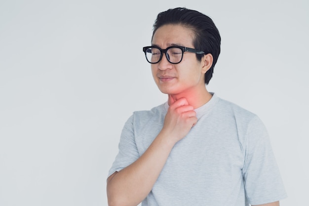 写真 喉の痛みを持つアジア人男性の写真