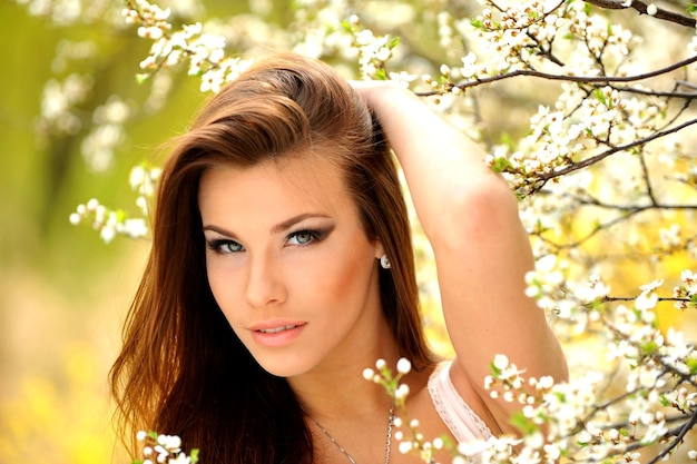 Фото Фото красивой молодой девушки на природе модели возле ярких цветущих деревьев