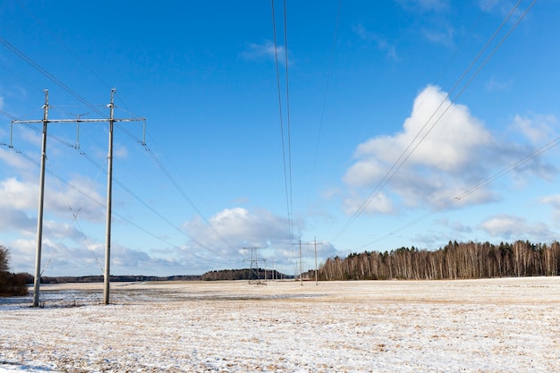 写真 冬季の高圧送電線の写真。青い空と白い雪