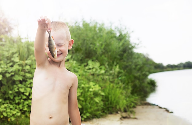 Фотография маленького мальчика, поймавшего рыбу