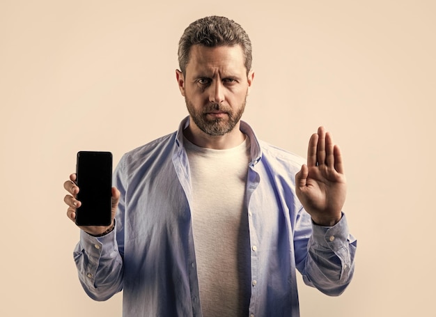 Фото Фото человека, показывающего телефонное приложение и без жестов человек, показывающий телефонное приложение, изолированный на фоне студии человек, показывают телефонное приложение в студии, показывающие телефонное приложение