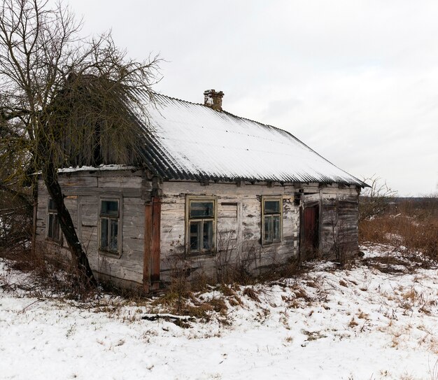 Фото Фотография старого разрушающегося дома, засыпанного снегом после снегопада