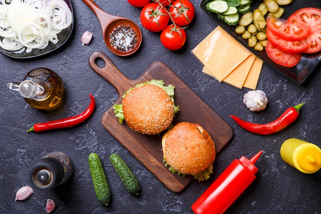 Фото Фото сверху двух гамбургеров, перец чили, сыр, помидор