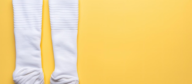 Photo of a pair of white socks lying on a vibrant yellow background with copy space