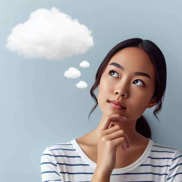 Photo photo of a pensive brunette holding her chin and looking up with thought cloud drawn above her head