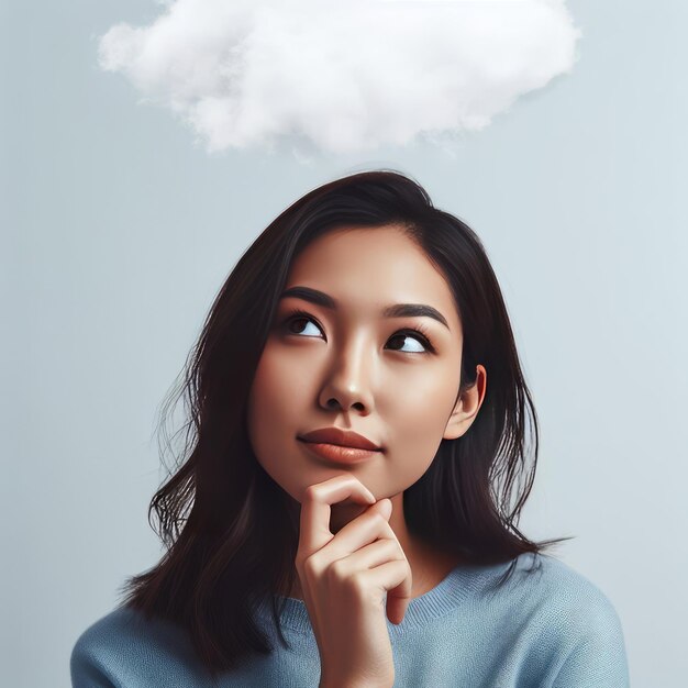 Photo photo of a pensive brunette holding her chin and looking up with thought cloud drawn above her head