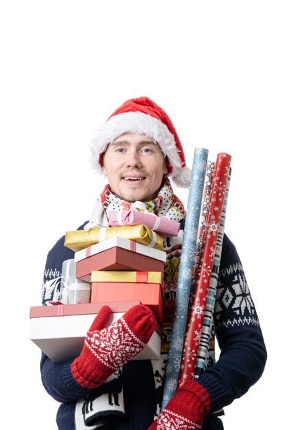 산타스 모자를 입고 선물 상자를 들고 손에 포장 종이를 싸고 있는 사려 깊은 남자의 사진